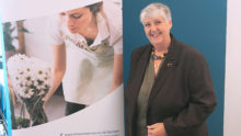 Fair Start Scotland participant Trish stands next to a Fair Start Scotland pop-up banner