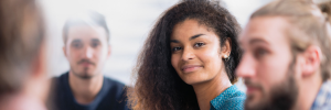 Young woman and two young men engaged in group conversation