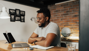 Young man on a video call, sitting at a breakfast bar in the kitchen